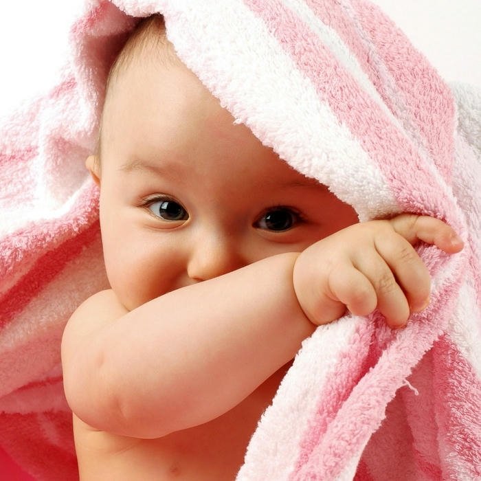 Cute baby pink towel wrapped smiling happy face