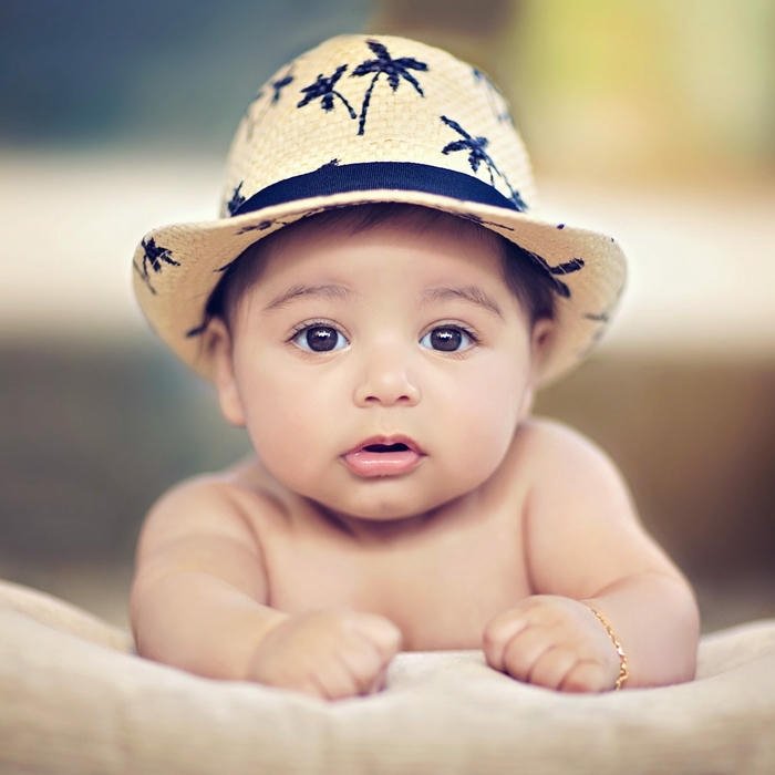 Cute baby wearing hat lying stomach smiling happy