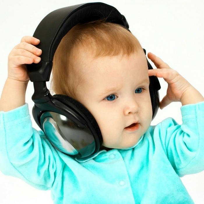 Funny baby wearing big headphones listening music blue