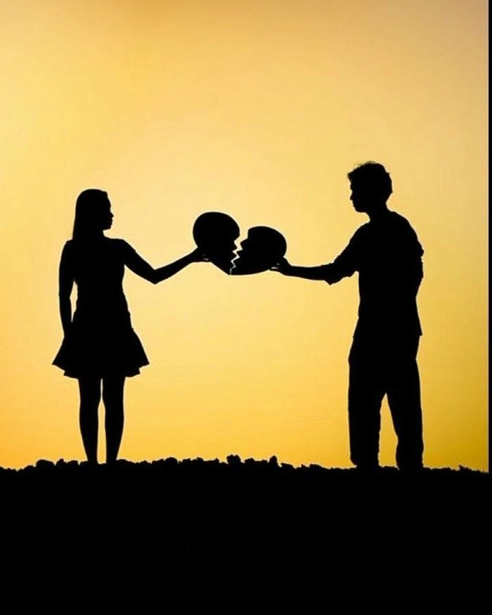 Love breakup images silhouette couple exchanging broken heart pieces.